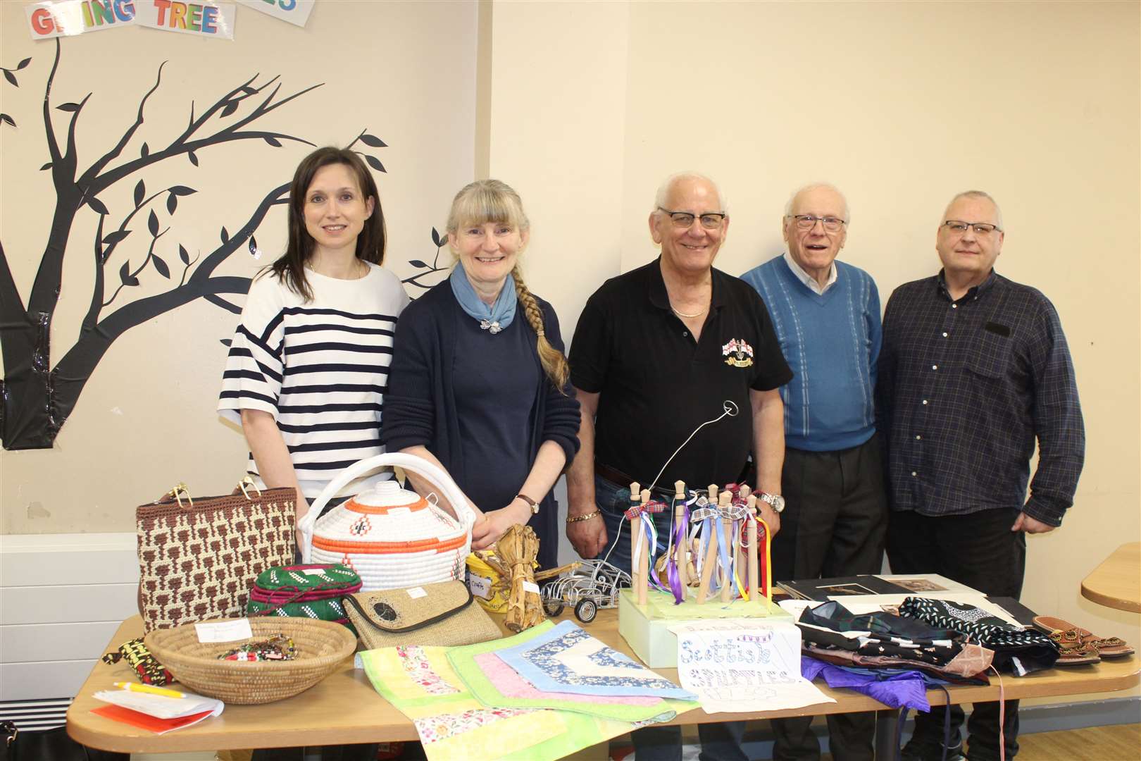 Sara Lucas (left) with St Kizito schools and community charity founder Rachel Rennie, Bob Durno, Ron Bird, Bruce Rennie, trustees and supporters with some Ugandan artefacts at Saturday's daffodil tea at the Catholic Church hall. Picture: Griselda McGregor