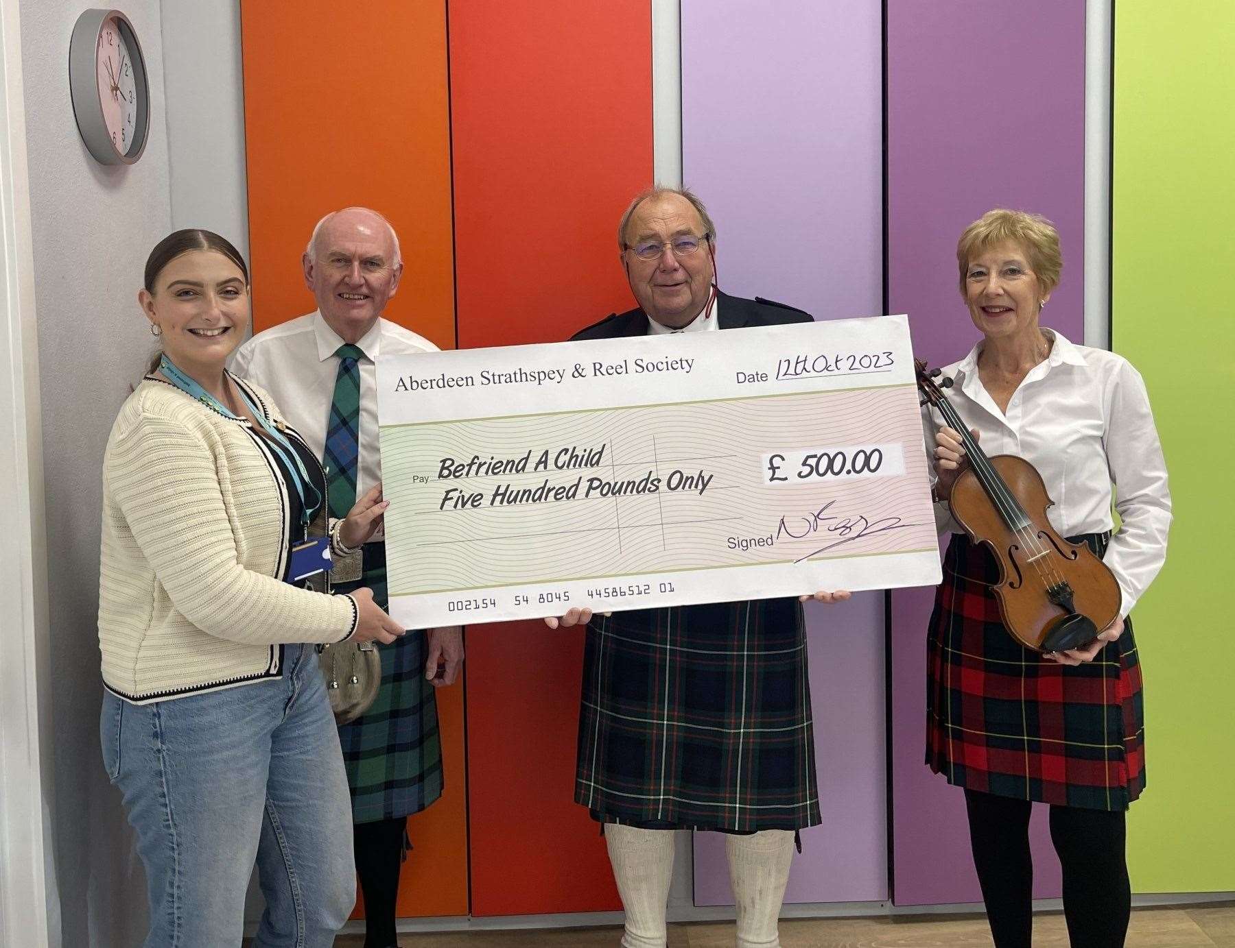 Befriend a Child’s Emily Findlay receives the fundraising cheque from Aberdeen Strathspey and Reel Society's Tom Cumming, Robin Ferguson and Fiona Dunbar.