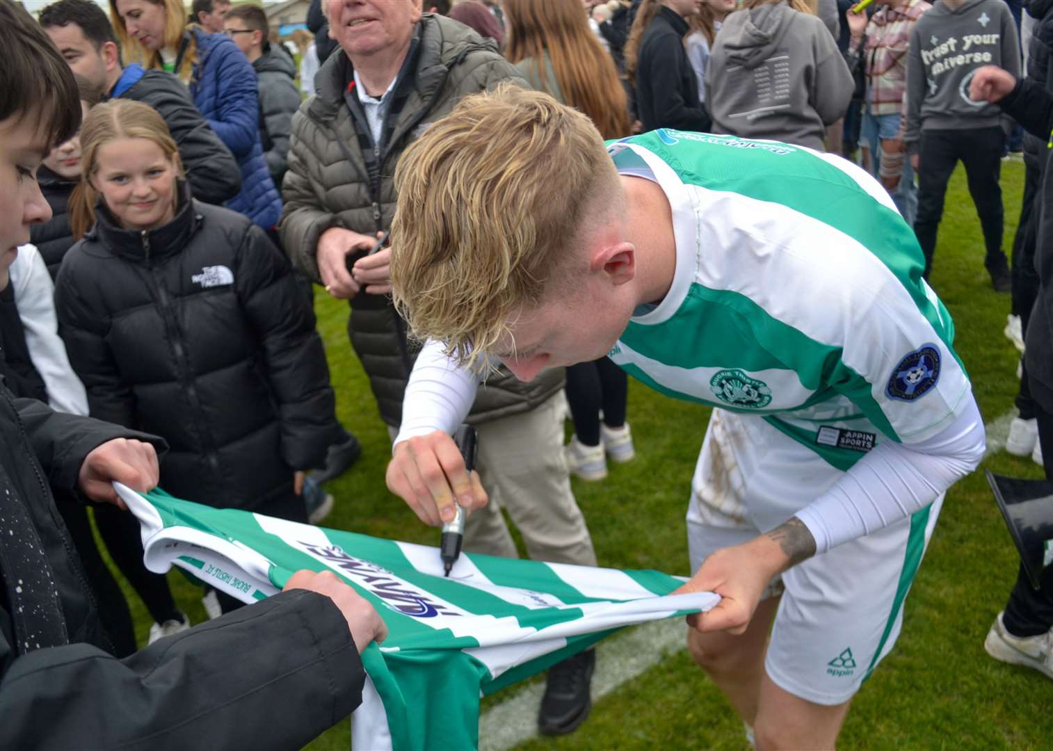 Buckie midfielder Jack MacIver signs a shirt after full-time. Picture: Tyler McNeill